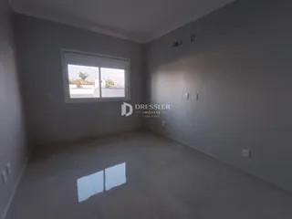 Vista interna de um cômodo com janela em uma residência.