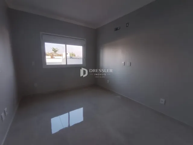 Vista interna de um cômodo com janela em uma residência.