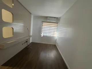 Sala de estar com piso de madeira e paredes brancas.