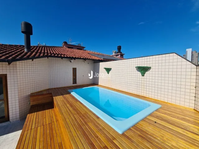 Foto de uma piscina ao ar livre com deck de madeira.