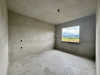 Foto de um cômodo interno vazio com piso de cerâmica e uma grande janela mostrando a paisagem externa.
