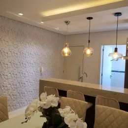 Ambiente interno com paredes brancas e iluminação embutida em um espaço residencial.