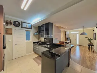 Foto da cozinha moderna com armários escuros e bancada de granito.