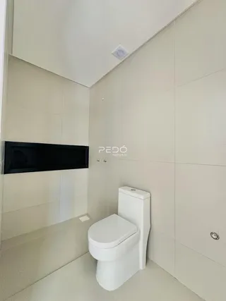 Foto de um banheiro com paredes claras e piso de cerâmica.