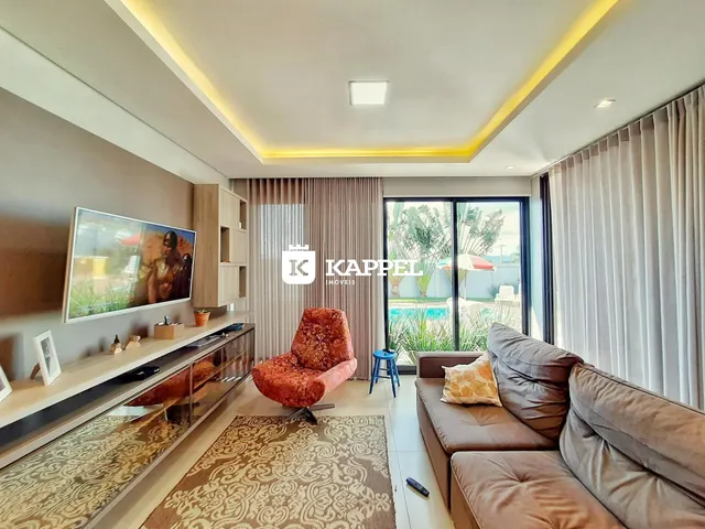 Sala de estar moderna com sofá e vista para o jardim e piscina.