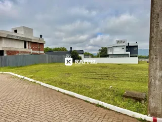Vista externa de uma propriedade residencial com gramado e construções ao fundo.