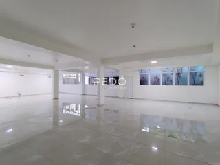 Espaço interno amplo e iluminado com piso reflexivo.