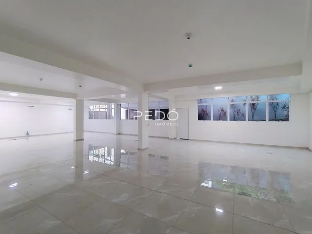 Espaço interno amplo e iluminado com piso reflexivo.