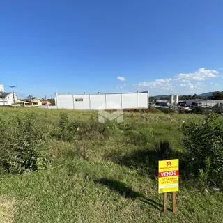 Paisagem de campo com um grande edifício branco ao fundo.
