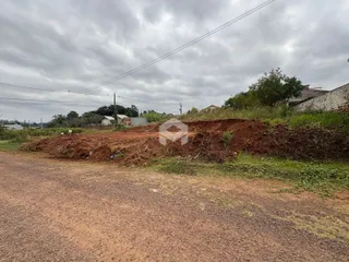 Vista da propriedade com terreno inclinado e estrada de terra.