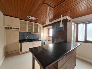 Foto de uma cozinha moderna com teto de madeira e armários brancos.