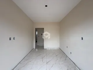 Corredor interno de uma residência com piso de porcelanato claro.