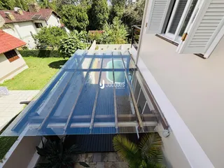 Vista da fachada de uma casa em Lajeado, Brasil, com estrutura de vidro.