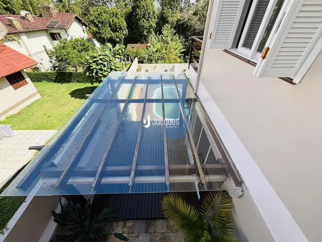 Vista da fachada de uma casa em Lajeado, Brasil, com estrutura de vidro.