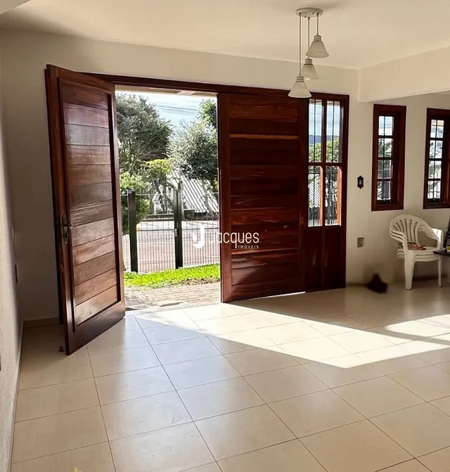 Vista interna de uma sala com portas de madeira e piso de cerâmica.
