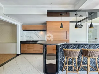 Imagem de uma cozinha moderna com ilha e revestimento de azulejos.