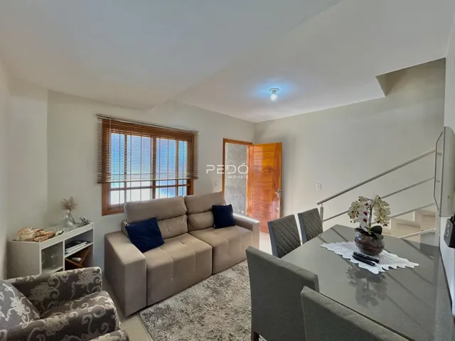 Sala de estar com sofá e área de jantar em imóvel no Brasil.