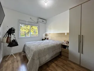 Quarto com cama e armário em ambiente claro.