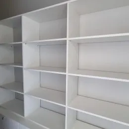 Prateleiras brancas de armazenamento em um ambiente interno.