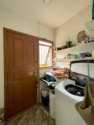 Interior de uma sala com porta de madeira e janela.