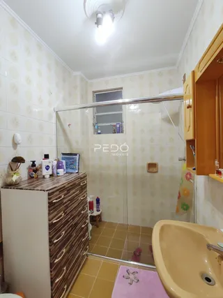 Foto de um banheiro com revestimento de cerâmica e box de vidro.