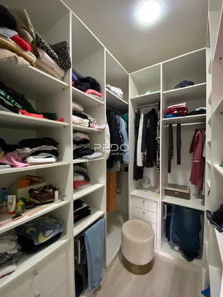 Foto de um ambiente interno com estantes e roupas.