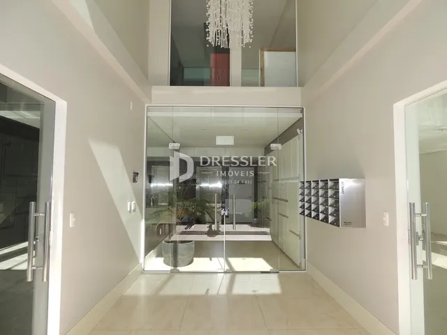 Hall de entrada com divisórias de vidro em um imóvel.