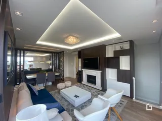 Sala de estar moderna com sofá e televisão em um imóvel no Brasil.
