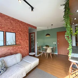 Sala de estar com parede de tijolos aparentes e piso de madeira.