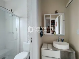 Foto de um banheiro interno com vaso sanitário e pia brancos.
