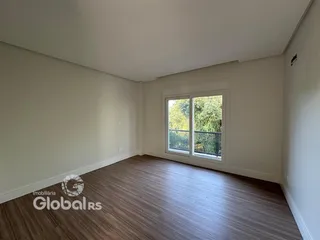 Sala com piso de madeira e janela iluminada.