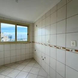 Foto de um corredor interno com paredes brancas e piso de azulejos brancos.