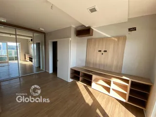 Ambiente interno com piso de madeira e portas de vidro que dão acesso a uma área externa.