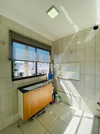 Foto de um cômodo interno com paredes de azulejo e janela.
