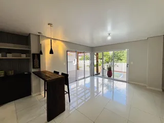 A sala de estar é um espaço amplo com portas de vidro que dão acesso a uma área externa.