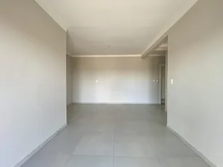 Hall de entrada com paredes brancas e piso claro.