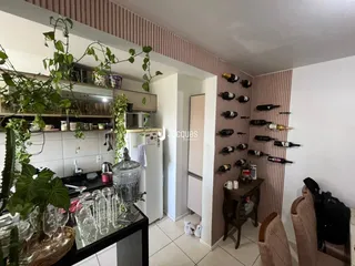 Ambiente de cozinha e sala de estar aberta com decoração de plantas.