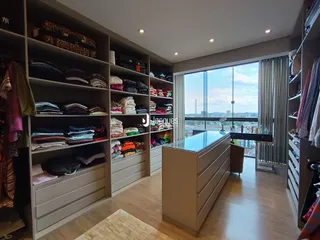 Interior de um ambiente com grandes armários de roupas e vista para o exterior.