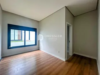 Sala de estar com grande janela e piso de madeira.