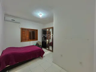 Quarto com cama e armário de madeira em um ambiente claro.