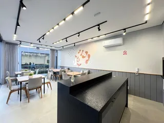 Ambiente moderno com mesas e cadeiras em um espaço aberto.