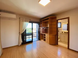 Sala de estar com piso de madeira e porta de vidro abrindo para a varanda.