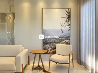 Sala de estar com sofá branco e arte de paisagem na parede.