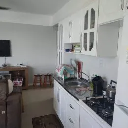 Uma cozinha com armários brancos e bancada visível.