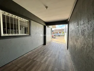 Foto de um corredor interno com piso de cerâmica e janela na parede esquerda.
