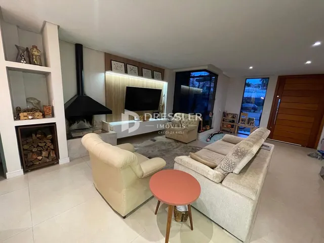 Sala de estar moderna com lareira e sofás.