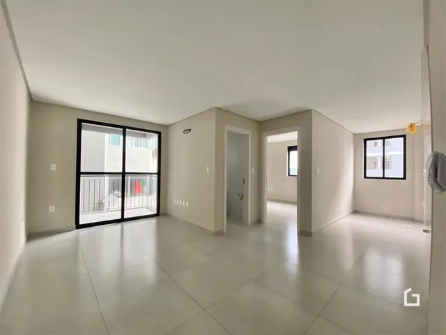 Hall de entrada com piso claro e portas de vidro.