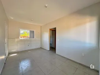 Uma sala ampla com piso de cerâmica e uma janela visível.