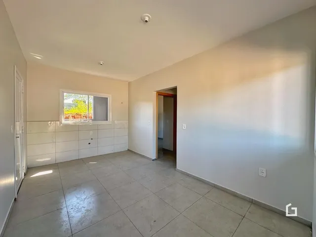 Uma sala ampla com piso de cerâmica e uma janela visível.