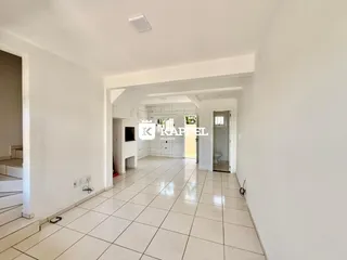 Foto de um corredor interno com piso de cerâmica claro e paredes brancas.